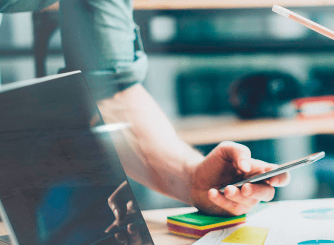 Mød dit nye digitale ERP-system – Microsoft Dynamics 365 Digital mand med mobiltelefon og computer